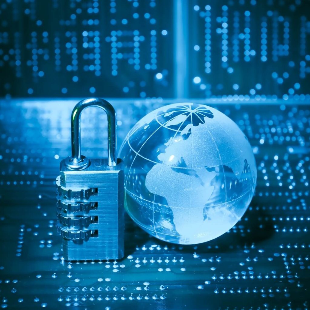 Image of a padlock on the left side of a globe underneath computer hardware